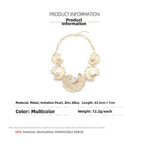 Detailed specs of gold alloy geometric necklace with baroque faux pearls and textured metal