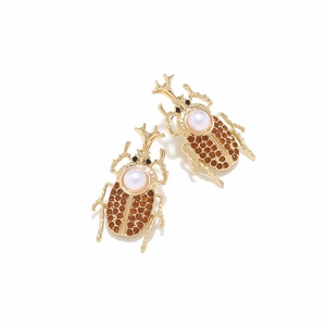 Detail of vintage beetle earrings with rhinestones and white pearls on gold alloy