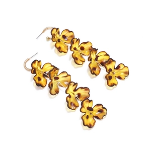 Detail of tiered leopard print petal earrings with amber resin and gold hooks