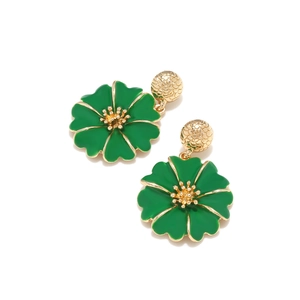 Détail de boucles d'oreilles fleurs en émail vert avec étamines dorées et puces billes
