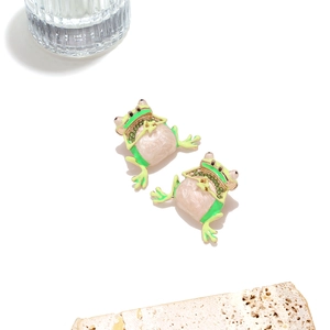 Dettaglio di orecchini a rana in smalto verde con base dorata e strass scintillanti