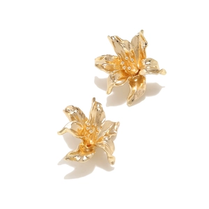 Detailed macro view of vintage gold metal flower earrings with textured 3D petals