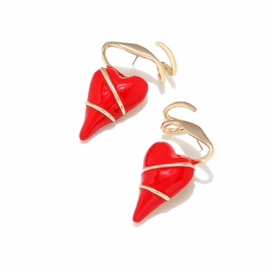 Vue détaillée des boucles d'oreilles cœur en émail rouge avec ornements en métal doré