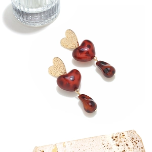 Detail of vintage heart earrings with leopard resin and gold hammered metal texture