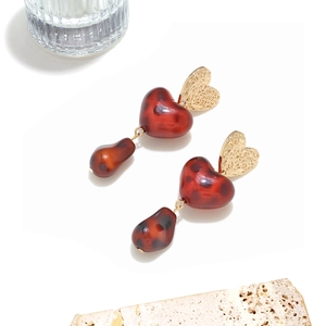 Detail of heart-shaped gold stud earring with leopard print resin heart and drop pendants