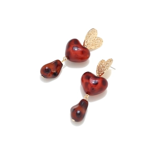 Detail shot of heart-shaped leopard print earrings with gold镂空 and resin texture