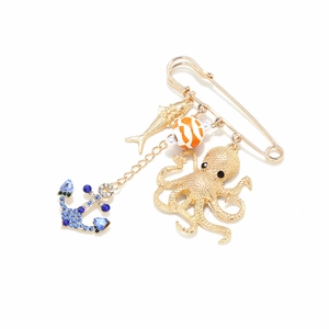 Golden ocean brooch with colorful anchor and octopus charms on white background