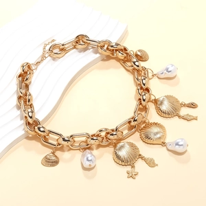 Details einer goldenen Gliederkette mit Muschel-, Seestern- und Barockperlen-Anhängern