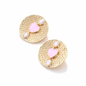 Detail of vintage gold hammered earrings with pink heart and white opal accents