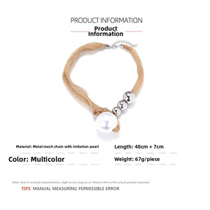 Detailed view of gold mesh chain necklace with silver beads and large faux pearl pendant