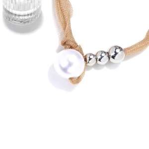 Detail of grey mesh cord necklace featuring a large white pearl and polished silver beads
