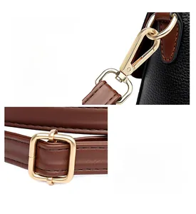 Detailed macro view of golden zinc alloy hardware on a black pebbled leather handbag