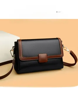 Detail view of vintage contrast leather crossbody bag with brown trim and metal buckle