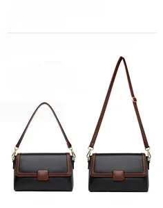 Dual strap detail of black grain leather bag showing short handle and long crossbody strap