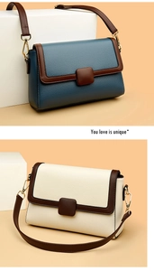Detail of pebbled leather crossbody bags in navy and cream with golden hardware