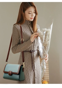 Detail view of the vintage green crossbody bag showing pebbled leather texture and gold buckle
