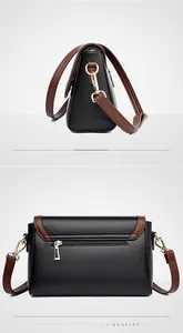 Detailed view showing black lychee leather texture and back zipper pocket of the crossbody bag