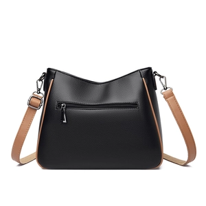 Minimalist black lychee texture crossbody bag with brown trim and adjustable strap