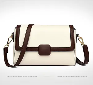 Detail of off-white crossbody bag featuring lychee texture and brown contrast flap