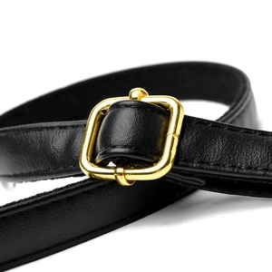 Détail de la bandoulière de sac en cuir noir avec boucle métallique dorée réglable