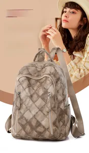 Close-up of brown PU leather backpack with classic diamond quilting and zip pockets