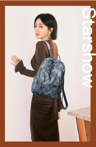 Close-up of quilted blue PU leather backpack showing multi-pocket design and texture