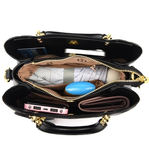 Détail de l'intérieur d'un sac à main matelassé noir montrant trois compartiments de rangement