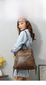 Brown vintage faux leather backpack with colorful ethnic woven strap detail on model