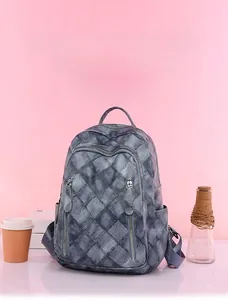 Close-up of diamond lattice stitching and vertical zippers on gray PU leather backpack