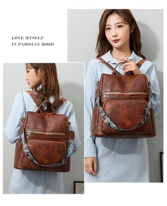 Close-up of brown vintage leather backpack featuring a bohemian ethnic style wide strap