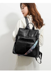 Detail of black textured PU leather backpack with colorful bohemian printed shoulder straps