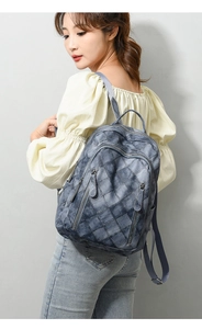 Close-up of deep blue checkered texture and multi-zipper pockets on the PU leather backpack