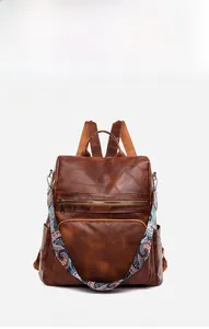 Close-up of brown PU leather backpack texture and colorful ethnic style strap detail