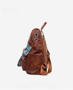 Side view of vintage brown PU leather backpack with ethnic pattern strap and side pocket