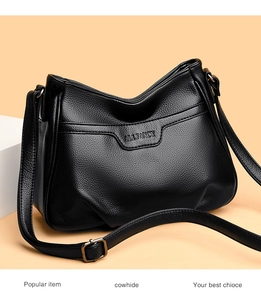 Close-up of black cowhide hobo bag with embossed logo and premium lychee texture