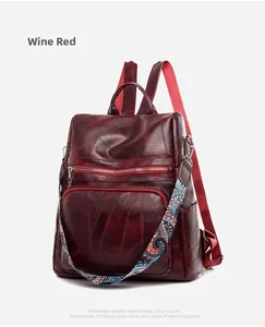 Detail view of wine red PU leather backpack with vintage texture and colorful printed strap