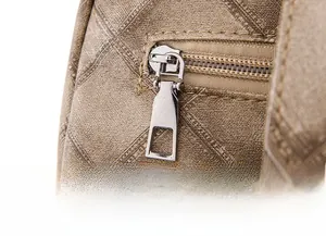 Detailed macro of smooth silver metal zippers on champagne woven textured backpack