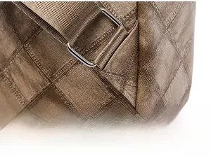 Detail showing reinforced triangle stitching and metal buckle on brown PU leather backpack