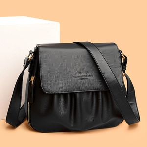 Dettaglio borsa a tracolla in pelle nera martellata con pieghe chic e finiture dorate lucide