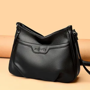 Close-up of black lychee grain leather crossbody bag with silver buckle and embossed logo