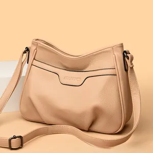 Detail of beige lychee pattern faux leather shoulder bag with adjustable strap buckle