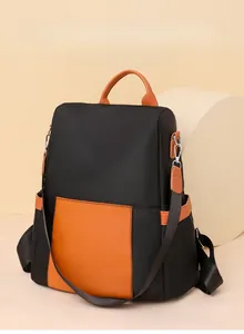 Detail of waterproof black nylon and orange leather contrast on fashion backpack