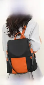 Detail of waterproof coated nylon and orange leather patchwork backpack for women