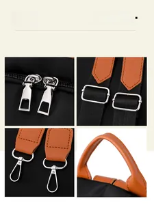 Detail view of silver zippers, metal buckles, and brown leather handles on a black backpack