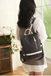 Détail d'un sac à dos antivol en tissu Oxford noir porté par un mannequin féminin