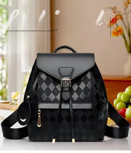 Close-up of black quilted leather backpack with flap closure and smiley charm