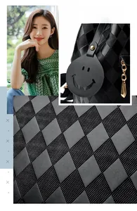 Detail view of black quilted faux leather backpack featuring checkered texture and charms