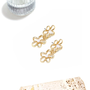 Golden layered flower earrings with pearls on elegant white and marble background