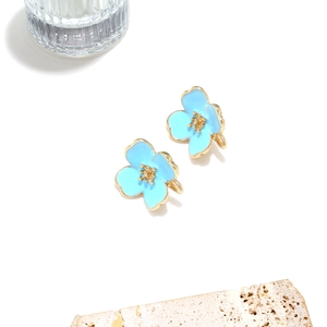 Elegant light blue enamel flower stud earrings with gold plating on minimalist background