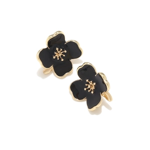 Macro detail of elegant flower stud earrings with black enamel petals and gold edges